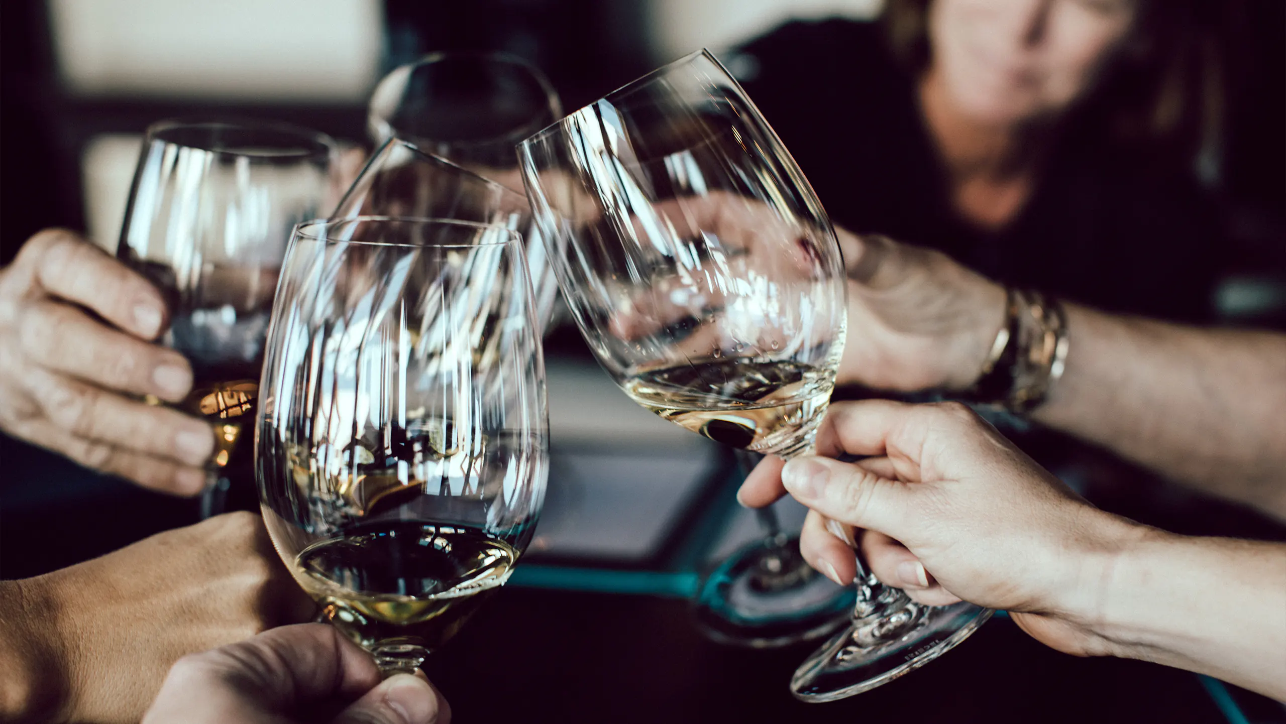 Anstoßen mehrerer Personen mit Weingläsern zur Feier der Veranstaltungen im Kreis Heinsberg für Juni 2022